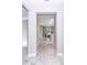 View down light and airy entryway with stylish light-colored wood-look flooring into kitchen and living area at 7542 Sw 128 Terrace Rd, Dunnellon, FL 34432
