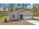 Charming single-story home featuring a gray facade, attached garage, and a well-manicured lawn at 7542 Sw 128 Terrace Rd, Dunnellon, FL 34432