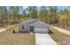 Charming single-story home with a grey exterior, white garage door, and well-maintained lawn at 7542 Sw 128 Terrace Rd, Dunnellon, FL 34432