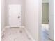 View down white hallway with stylish light-colored wood-look flooring; white interior doors with black hardware at 7542 Sw 128 Terrace Rd, Dunnellon, FL 34432