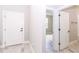 Hallway with white doors and light grey wood-look tile floor at 7542 Sw 128 Terrace Rd, Dunnellon, FL 34432