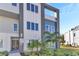 Modern building entrance with palm trees and landscaping at 7770 Sandy Ridge Dr # 240, Kissimmee, FL 34747