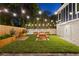 Landscaped backyard with picnic table, string lights, and wooden fence at 806 Palmer St, Orlando, FL 32801