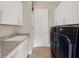 Bright laundry room with white cabinets, granite countertop, and washer/dryer at 8758 Pinter St, Orlando, FL 32827