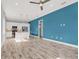 Open living room with kitchen island, hardwood floors, and blue accent wall at 8758 Pinter St, Orlando, FL 32827