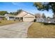 Tan house with a two-car garage and white fence at 110 Oak St, Clermont, FL 34711