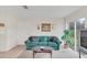 Living room with teal couch and access to backyard at 1209 W 6Th St, Sanford, FL 32771