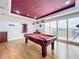 Game room features a pool table, wood floors, and access to an outdoor balcony at 12812 Jacob Grace Ct, Windermere, FL 34786