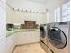 Bright laundry room with white cabinets, granite countertop, and modern appliances at 12812 Jacob Grace Ct, Windermere, FL 34786