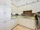 Laundry room with white cabinets, granite countertop, and modern appliances at 12812 Jacob Grace Ct, Windermere, FL 34786