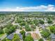 A broad aerial view displays an expansive residential community surrounded by dense green trees and blue skies at 13111 Point O Wood Ct, Orlando, FL 32828