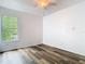 Bedroom featuring gray wood flooring, a window, and a ceiling fan at 13111 Point O Wood Ct, Orlando, FL 32828