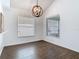 Bright dining room with wood floors, modern light fixture, and natural light from two large windows at 13111 Point O Wood Ct, Orlando, FL 32828