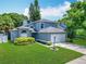 Charming home features a manicured lawn, two-car garage, and lush landscaping at 13111 Point O Wood Ct, Orlando, FL 32828