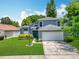Beautiful blue home with manicured lawn, landscaping, and a two-car garage at 13111 Point O Wood Ct, Orlando, FL 32828