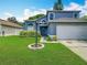 Inviting home with a lush lawn, landscaping, and attached two-car garage at 13111 Point O Wood Ct, Orlando, FL 32828