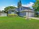 Charming two-story home with a manicured lawn, lush landscaping, and an attached two-car garage at 13111 Point O Wood Ct, Orlando, FL 32828