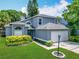 Charming two-story home with a manicured lawn, lush landscaping, and an attached two-car garage at 13111 Point O Wood Ct, Orlando, FL 32828