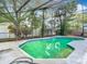 Sparkling pool with screened enclosure surrounded by mature trees at 13111 Point O Wood Ct, Orlando, FL 32828