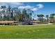 Community playground with wooden playset and slide, surrounded by green grass at 13556 Autumn Harvest Ave, Winter Garden, FL 34787