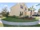 Two-story house with tan exterior, brown accents, landscaping, and a curved walkway at 1504 Oak Marsh Loop, Davenport, FL 33837