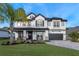 Two-story house with gray and white exterior, landscaping, and three-car garage at 15863 Burch Island Ct, Winter Garden, FL 34787