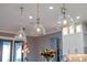 Glass globe pendant lights illuminate the kitchen island at 15863 Burch Island Ct, Winter Garden, FL 34787