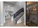 Dark wood staircase with metal balusters, next to a glass-front wine cellar at 15863 Burch Island Ct, Winter Garden, FL 34787