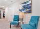 Upstairs hallway with two teal accent chairs, end table, and framed artwork at 1611 Kona Ln, Davenport, FL 33897