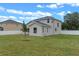 Spacious backyard view of home featuring manicured lawn, white fence, and cloudy blue sky at 1700 Underwood Ave, St Cloud, FL 34771