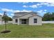 Backyard view of home with a well-maintained lawn, white fence, and clear blue sky at 1700 Underwood Ave, St Cloud, FL 34771