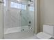 Sleek bathroom with glass shower enclosure, white tile, and a view from the window at 1700 Underwood Ave, St Cloud, FL 34771