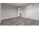 Bedroom featuring wood-look floors, base molding, and access to a closet and adjoining room at 1700 Underwood Ave, St Cloud, FL 34771