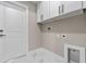 Well-lit laundry room with marble floors, white cabinets, and modern fixtures at 1700 Underwood Ave, St Cloud, FL 34771
