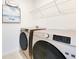 Laundry room with modern washer and dryer, and overhead shelving at 1991 Hemingway Cir, Groveland, FL 34736