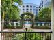 Beautiful pool area with lush landscaping, wrought iron fence, and an arched entrance at 202 E South St # 1050, Orlando, FL 32801