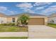 Tan house with gray roof, palm tree, and a two-car garage at 213 Lake Lucerne Way, Winter Haven, FL 33881