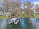 Aerial view of house with boat dock in the lake surrounded by mossy trees at 2250 W County Road 44, Eustis, FL 32726