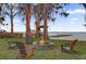 Picturesque firepit with Adirondack chairs by the water, ideal for relaxation and gatherings at 2250 W County Road 44, Eustis, FL 32726