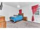 Bright bedroom with wood furniture, blue bedding, and red curtains at 2300 Grasmere View S Pkwy, Kissimmee, FL 34746