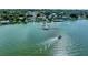 Aerial view of boat on lake with docks and waterfront neighborhood in the background at 2523 Avalon Park Blvd, Tavares, FL 32778