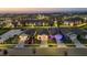 An aerial view of a new residential community at dusk, showcasing well-lit homes at 2523 Avalon Park Blvd, Tavares, FL 32778