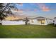 Large backyard with green grass, white vinyl fence and beautiful sunset view at 2523 Avalon Park Blvd, Tavares, FL 32778