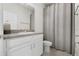 Well-lit bathroom with a vanity, toilet, and shower with a curtain at 2523 Avalon Park Blvd, Tavares, FL 32778