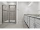 Spacious bathroom featuring a glass shower and double vanity with granite countertops and white cabinets at 2523 Avalon Park Blvd, Tavares, FL 32778