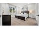 This bedroom boasts neutral walls, carpet, a dark wood bed frame and black and white art at 2523 Avalon Park Blvd, Tavares, FL 32778