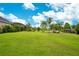 Green grassy backyard, palm trees, and lake access at 2682 Wyndsor Oaks Pl, Winter Haven, FL 33884