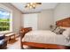 Bright bedroom with wood flooring, a large window, and a wooden bed frame at 2682 Wyndsor Oaks Pl, Winter Haven, FL 33884