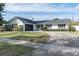 White house with black garage door, landscaping, and long driveway at 2779 Prince John Rd, Winter Park, FL 32792