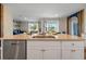 Kitchen island with sink, stainless steel dishwasher, and view to living room at 2944 Moulin Rd, Davenport, FL 33837